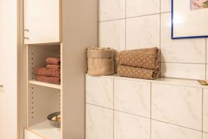 a bathroom with white tiled walls and white towels at Relaxen am Illmensee in Illmensee +28 photos