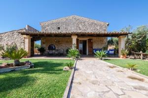 a stone house with a patio and a yard at Finca Fonoll in Santa Margalida