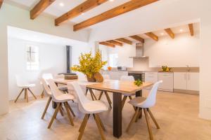 a kitchen and dining room with a wooden table and chairs at Finca Rafal in Son Servera