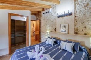 a bedroom with a blue bed with white towels on it at Finca Fonoll in Santa Margalida +30 photos