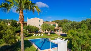 an aerial view of a house with a swimming pool and a palm tree at Finca Rafal in Son Servera