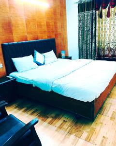 a bedroom with a large bed with white sheets at The Plaza Dalhousie - Near Ghandhi Chowk Mall Road in Dalhousie