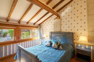 a bedroom with a blue bed in a room at Chambres d'hôtes Le Pré Fleuri in Saint-Sulpice-de-Roumagnac +91 photos