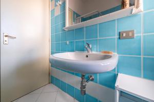 a bathroom with a white sink and blue tiles at Villetta Simius in Villasimius +21 photos