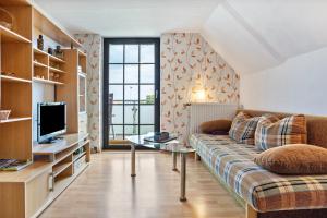 a living room with a couch and a tv at Feriendomizil Fliedereck in Malchin