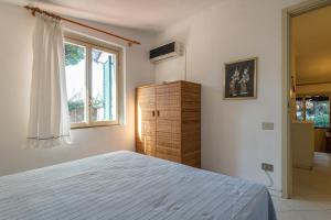 a bedroom with a large bed and a window at Villetta Simius in Villasimius