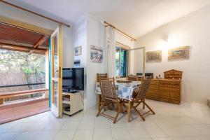 a dining room with a table and chairs and a television at Villetta Simius in Villasimius
