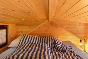 a bed in a room with a wooden ceiling at Tiny House Ernesto in Lehnin