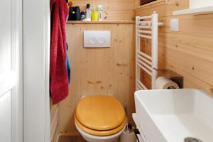 a bathroom with a wooden toilet and a sink at Tiny House Ernesto in Lehnin +17 photos
