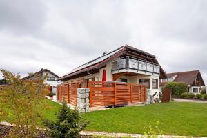 a house with a wooden fence in a yard at Haus Bross in Hayingen