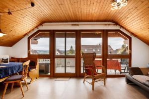 a living room with a table and chairs and windows at Haus Bross in Hayingen