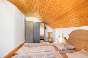 a bedroom with two beds and a wooden ceiling at Haus Bross in Hayingen