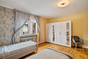a bedroom with a bed and a window and a chair at Apartment Albert-Schulte Park in Worms +17 photos