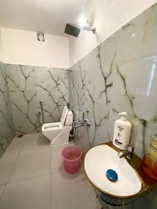 a bathroom with a sink and a toilet at Large room with terrace in Kolkata +26 photos