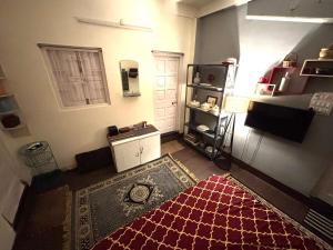 a living room with a red rug on the floor at Large room with terrace in Kolkata