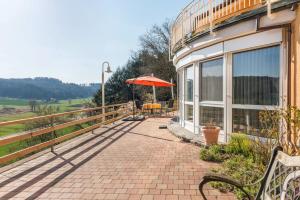 a patio with a bench and an umbrella at Ferienparadies Bodensee Fewo2 in Billafingen