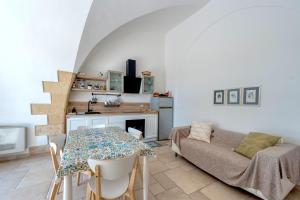 a kitchen and living room with a table and a couch at Villa Minioti Apartment A in Arnesano