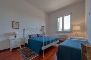 a bedroom with two beds and a window at Villa Minioti Apartment A in Arnesano