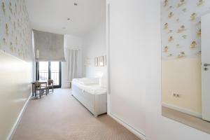 a white room with a bed and a chair at Haus Seezeit in Malchow