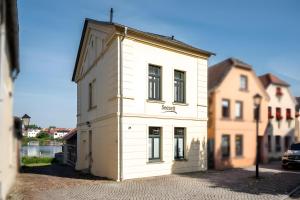 a white building sitting on the side of a street at Haus Seezeit in Malchow