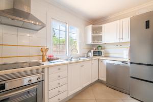 a white kitchen with white cabinets and a window at Alegrías in Marratxí 