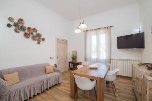 a living room with a table and a couch at Maison Chloe in La Maddalena