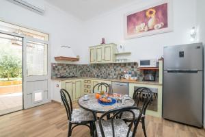 a kitchen with a table and chairs and a refrigerator at Maison Chloe in La Maddalena