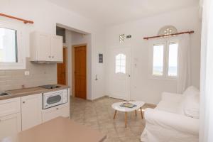 a kitchen and living room with a couch and a table at Anemologio 102 Tinos in Agios Ioannis