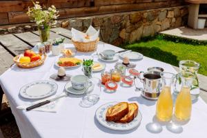 a white table with breakfast foods and drinks on it at Vernalhof Apt Sunnaseit in Sluderno
