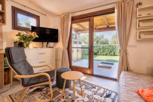a living room with a television and a table and a chair at Manessy in Badesi