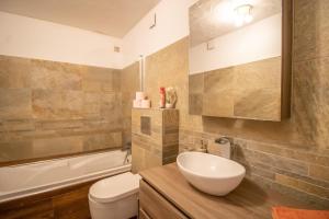 a bathroom with a sink and a toilet and a tub at Villa Solsticia in Albitreccia