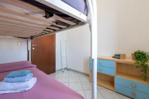 a bedroom with a purple bed and a desk at Bilocale Valledoria in Valledoria