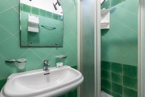 a green bathroom with a sink and a mirror at Bilocale Valledoria in Valledoria +22 photos