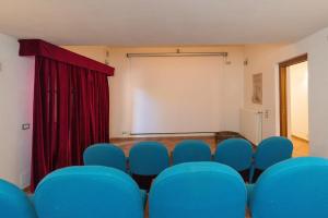 a room with blue chairs in front of a screen at Tenuta Vallegaia in Rosignano Marittimo +37 photos