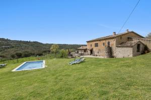 a large yard with a house and a swimming pool at Casamira in Sagás