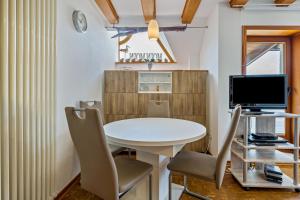 a small dining room with a white table and chairs at Moin Moin in Friedrichskoog-Spitze