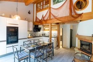 a kitchen and dining room with a glass table and chairs at Villa Patio Proche Plage in Seignosse