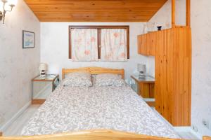 a bedroom with a bed with two night stands and a window at Villa Patio Proche Plage in Seignosse