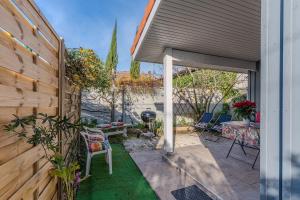 a backyard with a wooden fence and a patio at Chalet studio bassin d'Arcachon in La Teste-de-Buch