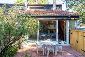 a patio with a table and chairs and a house at Villa Patio Proche Plage in Seignosse