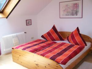 a bedroom with a wooden bed with two pillows at Haus Oettinger in Hayingen
