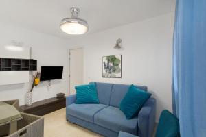 a living room with a blue couch and a tv at Casa Paula - 24 in Arinaga