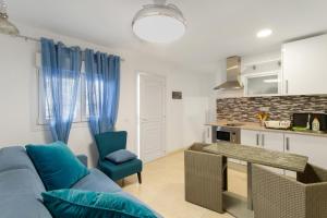 a living room with a blue couch and a kitchen at Casa Paula - 24 in Arinaga