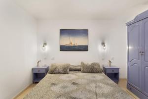 a bedroom with a bed and two dressers and a painting at Casa Paula - 24 in Arinaga +20 photos