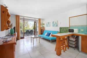 a kitchen and living room with a blue couch at Bungamerica272 in Playa de las Americas