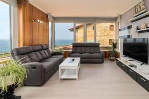 a living room with a couch and a television at Villa Laurana in Suances