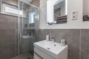 a bathroom with a white sink and a shower at Tinyhaus Brekendorf Kammberg in Brekendorf +21 photos