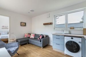 a living room with a couch and a washing machine at Tinyhaus Brekendorf Kammberg in Brekendorf