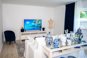 a living room with a white couch and a tv at Royal Delft Boutique Apartment in Dinslaken