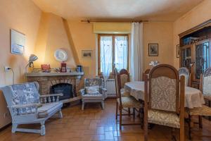 a living room with a fireplace and a table and chairs at Cottage Casa Luisa in Montalcino